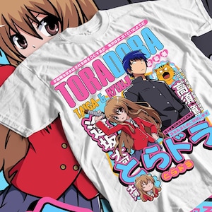 May include: White t-shirt featuring anime characters and Japanese text. The design includes the words "ToraDora" in pink and blue, along with illustrations of two characters and a tiger.