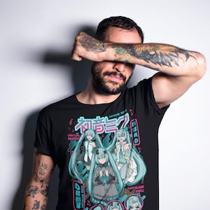 Puede incluir: Camiseta negra con un gr&aacute;fico de Hatsune Miku, una cantante virtual, con pelo y atuendos turquesa. El dise&ntilde;o incluye texto japon&eacute;s y el n&uacute;mero 01 en una combinaci&oacute;n de colores rosa y turquesa.