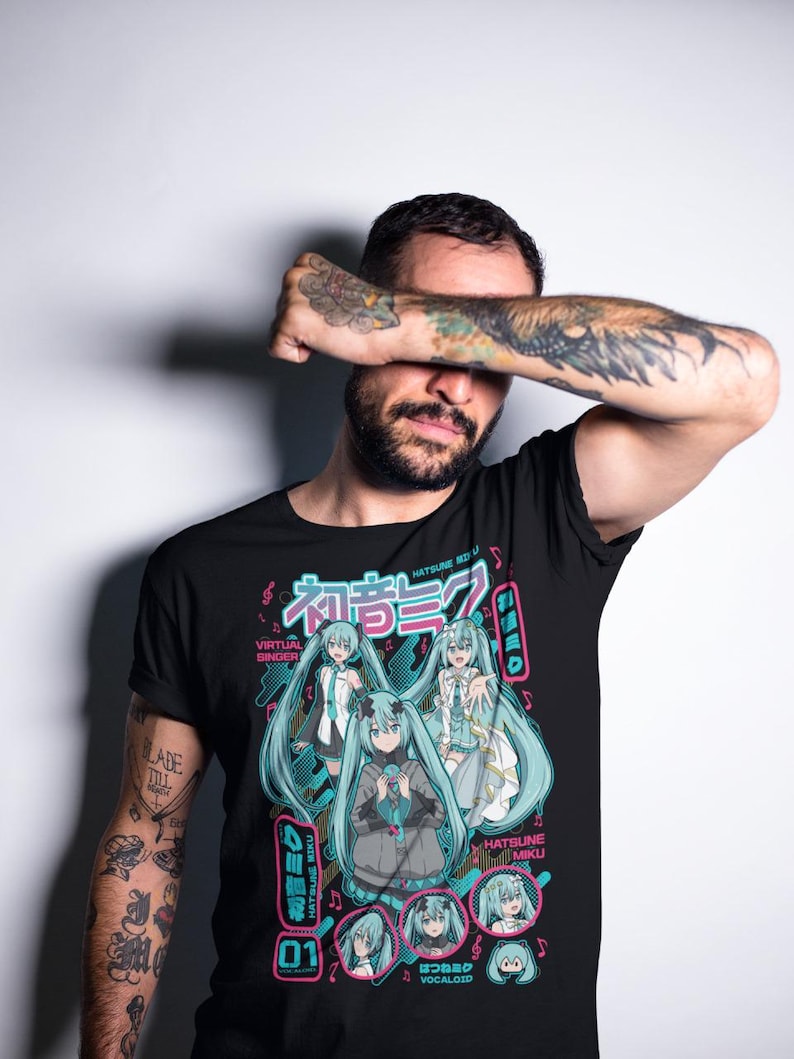 Puede incluir: Camiseta negra con un gr&aacute;fico de Hatsune Miku, una cantante virtual, con pelo y atuendos turquesa. El dise&ntilde;o incluye texto japon&eacute;s y el n&uacute;mero 01 en una combinaci&oacute;n de colores rosa y turquesa.
