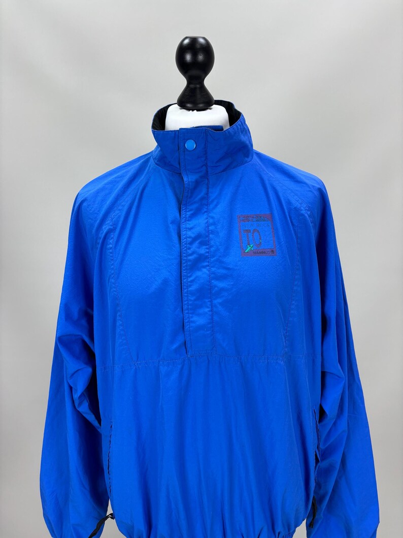 May include: A white ceramic mug with a black handle and the text "But First, Coffee" in a bold, black font. The mug is set against a neutral background, highlighting its simple design.