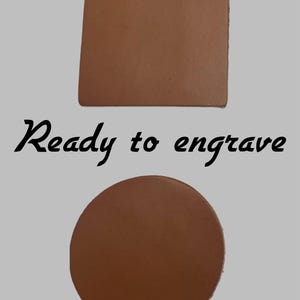 May include: Two brown leather coasters, one square and one round, are displayed against a light gray background. The text "Ready to engrave" is written in black script below the square coaster and above the round coaster.