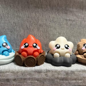 May include: Four small, stylized figurines representing elemental characters. From left to right: a blue water drop in a white base, a red flame in a brown log ring, a white cloud in a dark gray base, and a tan rock in a jagged brown base.