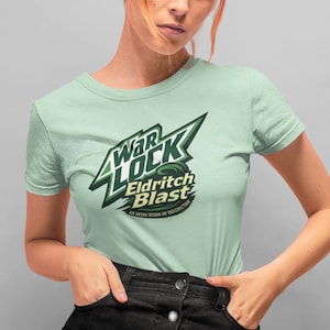 May include: A light green t-shirt with a green and yellow logo that says "Warlock Eldritch Blast" on it. The person wearing the shirt is also wearing a black denim skirt.