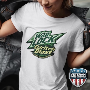 May include: White t-shirt with a green and black graphic that reads "War Lock Eldritch Blast: An Invocation of Destruction." The shirt also has a "Veteran Owned & Operated" badge.