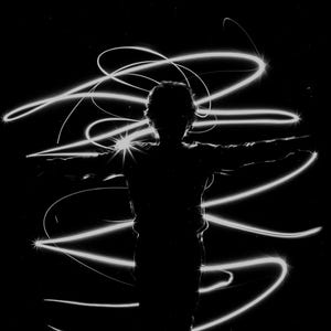 May include: A silhouette of a person with arms outstretched, surrounded by white light trails against a black background.