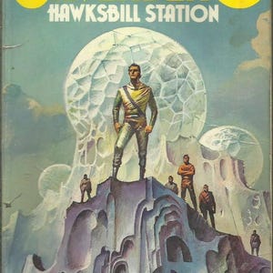 Puede incluir: Portada de libro de bolsillo vintage de "Hawksbill Station" de Robert Silverberg. La ilustraci&oacute;n muestra a un hombre con un atuendo futurista de pie sobre un paisaje rocoso, con otras figuras y grandes estructuras esf&eacute;ricas en el fondo. El t&iacute;tulo es amarillo.