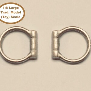 May include: Two silver metal rings, each with a rounded bar across the top. The rings are approximately 1 inch in diameter. The text "1:8 Large Trad. Model (Toy) Scale" is visible in the background.
