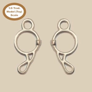 Puede incluir: Dos anillos de bocado de caballo de metal plateado, cada uno con un anillo circular y un bucle curvo abierto. Los anillos están diseñados para ser utilizados con una brida de caballo.