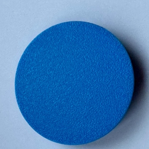 A solid blue circle with a textured surface. This shows the back of a motorhome or caravan bubble leveler.