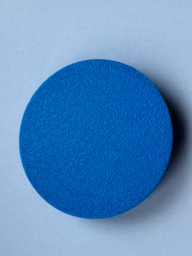 A solid blue circle with a textured surface. This shows the back of a motorhome or caravan bubble leveler.