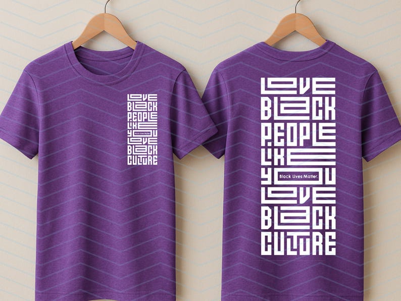May include: Purple t-shirts with the text "LOVE BLACK PEOPLE LIKE YOU LOVE BLACK CULTURE" in white block letters. The phrase "Black Lives Matter" is also included. The shirts are displayed on wooden hangers.