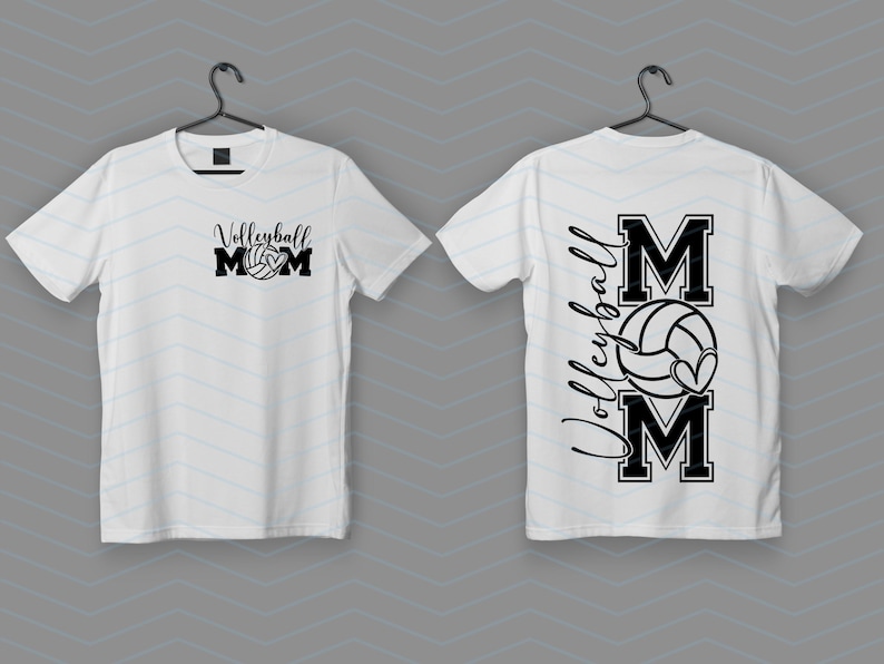 May include: Two white t-shirts with a black graphic. One says "Volleyball Mom" with a volleyball, the other has "Volleyball" vertically with "MOM" and a volleyball with a heart.