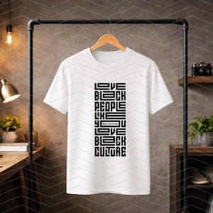 May include: White t-shirt with a black graphic design. The design features the words "LOVE BLACK PEOPLE LIKE YOU LOVE BLACK CULTURE" in a vertical, block-style font. The phrase "Black Lives Matter" is also included.