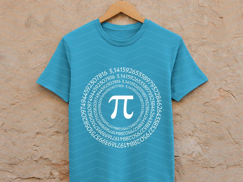 May include: A turquoise t-shirt featuring a white Pi symbol and a circular arrangement of numbers. The numbers are around the Pi symbol. The shirt is displayed on a wooden hanger.