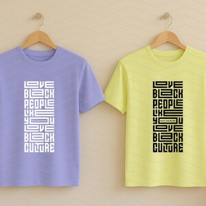 May include: Two short-sleeved t-shirts, one lavender and one yellow, hang on wooden hangers. Each shirt features the text "LOVE BLACK PEOPLE LIKE YOU LOVE BLACK CULTURE" in a vertical, blocky design. The text is white on the lavender shirt and black on the yellow shirt.