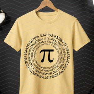 May include: A pale yellow t-shirt featuring a black Pi symbol encircled by a sequence of numbers. The tee is suspended on a wooden hanger, set against a dark backdrop.