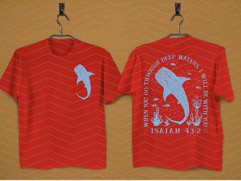 May include: Red t-shirts with a light blue whale shark design. One shirt has the shark on the front, the other has the shark and text: "WHEN YOU GO THROUGH DEEP WATERS, I WILL BE WITH YOU, ISAIAH 43:2."