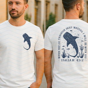 May include: White t-shirt with a navy blue whale shark graphic on the front and back. The back of the shirt features the text "WHEN YOU GO THROUGH DEEP WATERS, I WILL BE WITH YOU" and "ISAIAH 43:2" in navy blue.