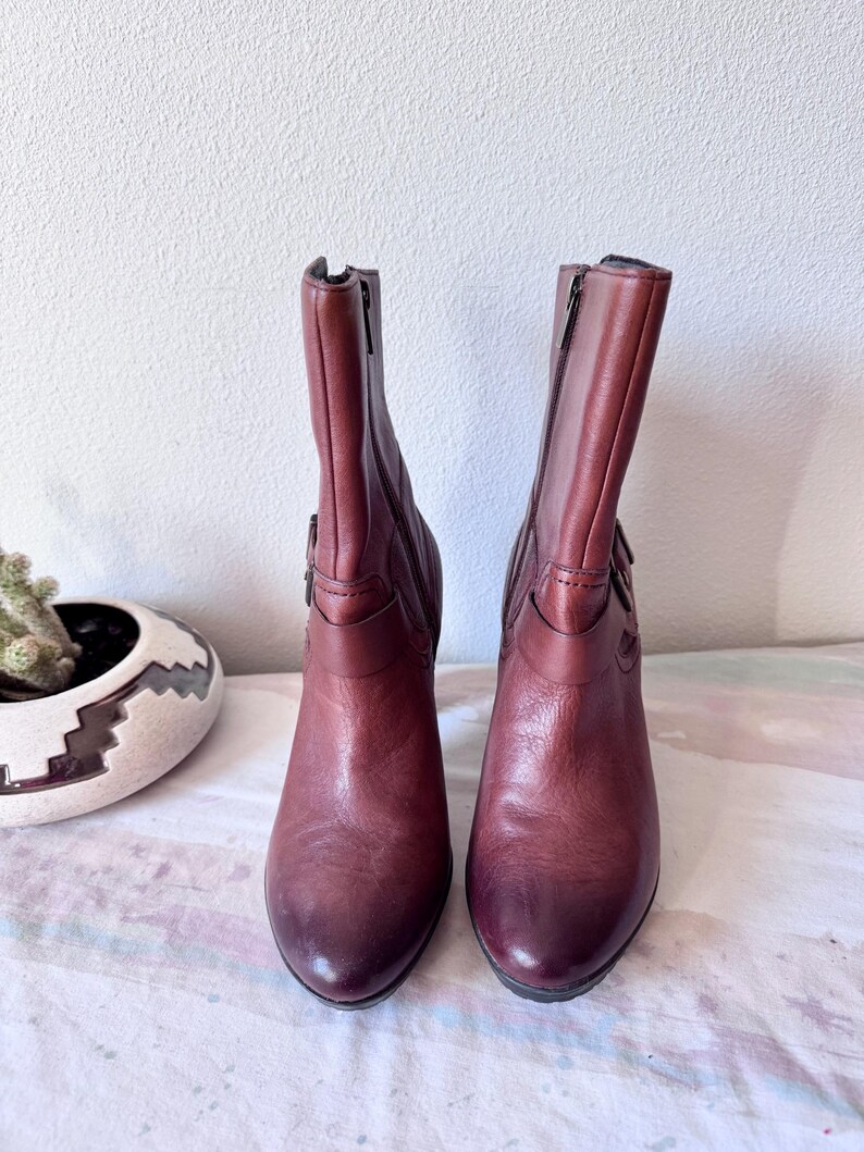 May include: A set of three ceramic mugs with a speckled, matte finish. The mugs are in shades of cream, light gray, and dark gray. Each mug has a simple, modern design and a rounded handle.