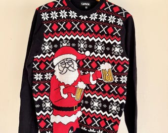 May include: Black Christmas sweater featuring a Santa Claus graphic holding a beer mug. The sweater has a festive pattern of red diamonds, white snowflakes, and geometric shapes. The brand name "CARSON" is visible on the collar.