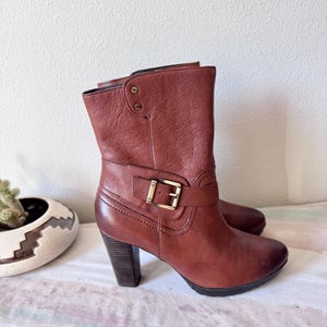 May include: A set of three ceramic mugs with a speckled, matte finish. The mugs are in shades of cream, light gray, and dark gray. Each mug has a simple, minimalist design, perfect for coffee or tea.