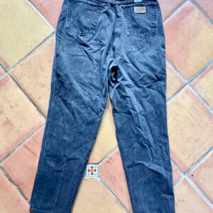 Op de afbeelding: Donker gewassen denim jeans met een klassiek vijf-zakken ontwerp. De jeans hebben een rechte pijp en een vervaagde uitstraling. De achterzakken en tailleband zijn zichtbaar, samen met een kleine leren patch.