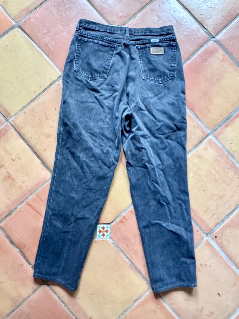 Op de afbeelding: Donker gewassen denim jeans met een klassiek vijf-zakken ontwerp. De jeans hebben een rechte pijp en een vervaagde uitstraling. De achterzakken en tailleband zijn zichtbaar, samen met een kleine leren patch.