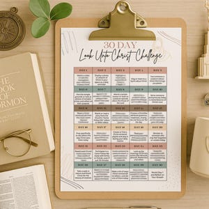 May include: A clipboard with a 30-day challenge chart titled "Look Unto Christ Challenge" sits on a wooden surface, alongside a book, glasses, and decorative items. The chart features daily prompts.