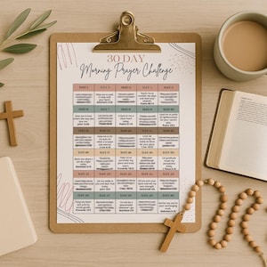 May include: A clipboard with a "30 Day Morning Prayer Challenge" chart, a cup of coffee, an open book, a rosary, and wooden crosses. The chart has a grid with daily prayer prompts. A sprig of leaves adds a natural touch to the scene.