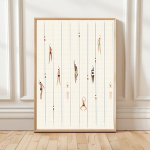 May include: Framed art print showing stylized swimmers in a pool. The artwork depicts figures in various swimsuits, with blue lane lines and red markers. The background is cream, and the frame is light wood.
