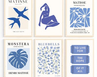 Op de afbeelding: Zes ingelijste kunstprints met blauwe illustraties op een crèmekleurige achtergrond, geïnspireerd op Matisse. De prints bevatten tekst zoals "MATISSE", "MONSTERA" en "BLUEBELLS". De kunstprints zijn in een galerijmuur opstelling.