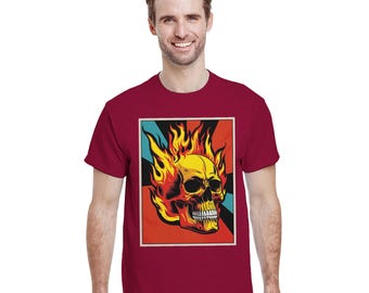 May include: A maroon t-shirt featuring a graphic of a yellow skull engulfed in flames. The skull is set against a backdrop of red, black, and teal. The shirt is a classic crew neck style.
