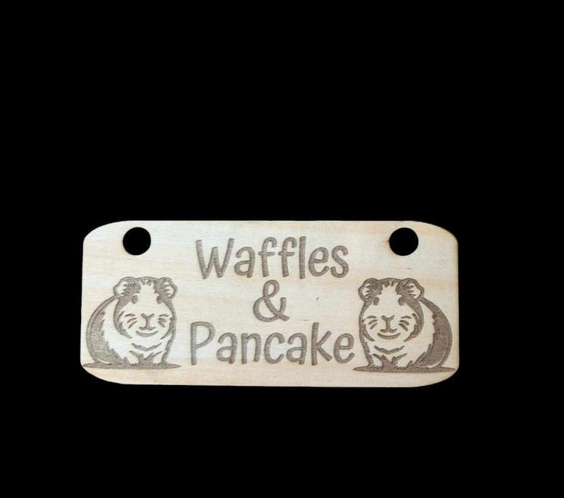 May include: A wooden sign with the text "Waffles & Pancake" and two cartoon guinea pigs on either side of the text.