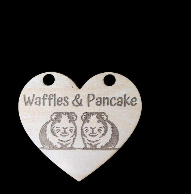 May include: Wooden heart-shaped tag with the text "Waffles & Pancake" and two guinea pigs engraved on it.