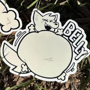 May include: A sticker featuring a cartoon fox character with a large belly. The fox is smiling with its mouth open, and the word "BELLY" is written in bold letters. The sticker has a white background with black outlines.