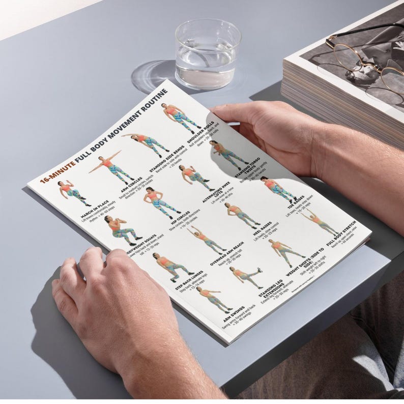 May include: A printed exercise routine titled "16-Minute Full Body Movement Routine." The page features illustrated figures demonstrating various exercises, including arm circles, side bends, and stretches. A glass of water and eyeglasses are also visible.