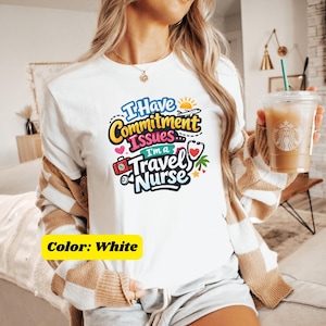 May include: White t-shirt with the text "I Have Commitment Issues... I'm a Travel Nurse" in colorful lettering. The design includes a stethoscope, airplane, suitcase, and palm tree. The shirt is a crew neck.