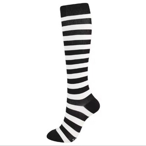 May include: A knee-high sock featuring a repeating horizontal striped pattern in black and white. The sock has a solid black heel and a solid black toe section, with the striped design continuing throughout the leg and foot portion of the garment.