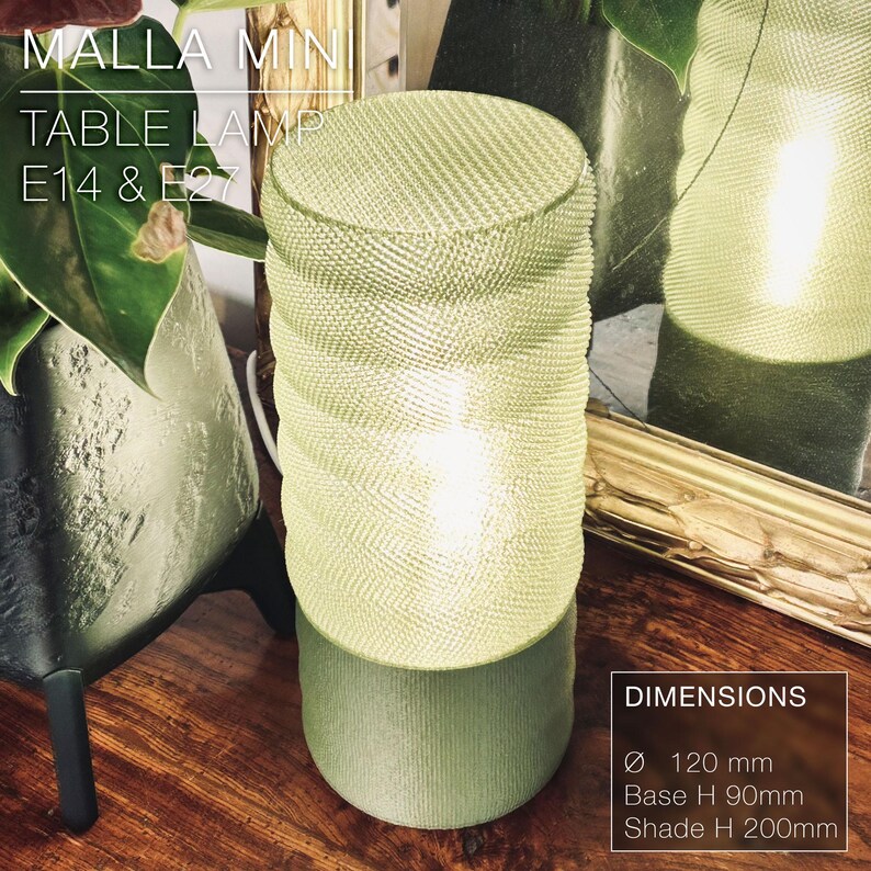 May include: A green table lamp with a woven shade and a white light shining through. The lamp is 120 mm in diameter, 90 mm tall at the base, and 200 mm tall at the shade. The lamp is labeled "MALLA MIN TABLE LAMP E14 & E27".