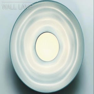 May include: A white and blue ripple wall lamp with a circular design. The lamp has a white light source in the center.