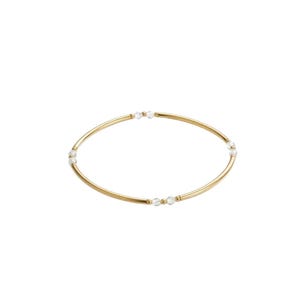 Op de afbeelding: Een goudkleurige armband met heldere, ronde kralen die gelijkmatig over de band zijn verdeeld. De armband is eenvoudig en elegant, geschikt voor dagelijks gebruik of speciale gelegenheden. Het ontwerp is minimalistisch en modern.