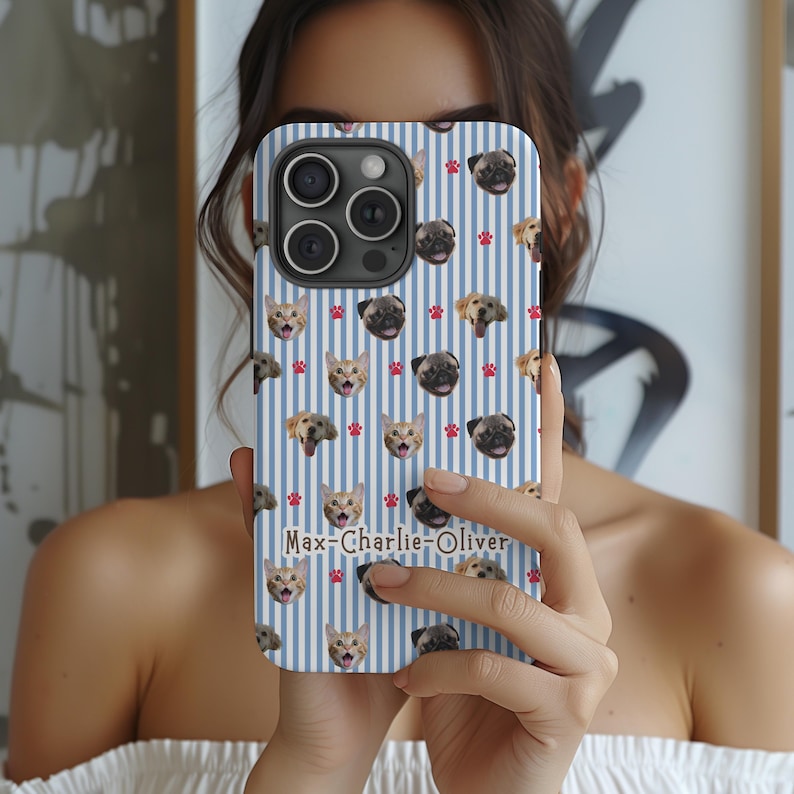 Puede incluir: Una funda de tel&eacute;fono con un dise&ntilde;o de rayas azules y blancas, adornada con im&aacute;genes de perros y gatos. Tambi&eacute;n presenta huellas de patas rojas y el texto "Max-Charlie-Oliver". La funda est&aacute; dise&ntilde;ada para un tel&eacute;fono m&oacute;vil.