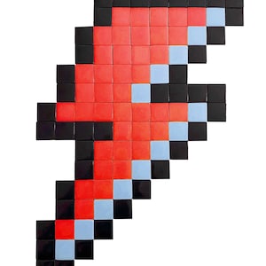 May include: A red, black, and light blue pixelated lightning bolt design. The design is made up of small square tiles.