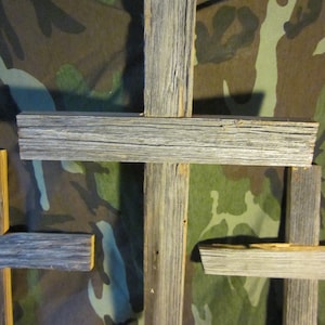 May include: Three rustic wooden crosses with a gray weathered finish. The crosses are made from reclaimed wood and have a natural, distressed look.