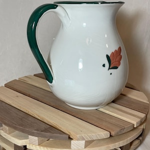White pitcher made in Italy with hand painted details.