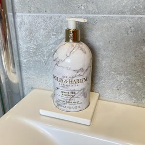 May include: A white and gray marble-patterned hand wash bottle with a gold pump, resting on a white square tray. The bottle is labeled "Baylis & Harding Elements White Tea & Neroli" and contains 500 ml / 16.9 fl oz.