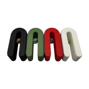May include: Four U-shaped wooden marble holders in black, green, red, and white. Each holder contains a colorful marble. The holders are arranged side by side against a white background. A fun and colorful toy.