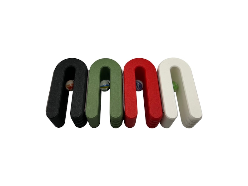 May include: Four U-shaped wooden marble holders in black, green, red, and white. Each holder contains a colorful marble. The holders are arranged side by side against a white background. A fun and colorful toy.