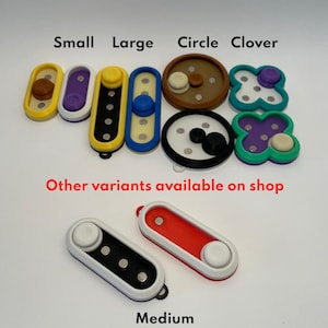 May include: An assortment of colourful fidget toys in various shapes, including small, large, circle, and clover. The toys are made of plastic and have different textures. The text "Other variants available on shop" is visible below the toys. The text "Medium" is visible below two red and white fidget toys.