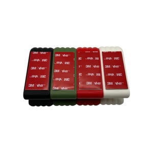 May include: Four rectangular adhesive holders in black, olive green, red, and white. Each has a red adhesive strip with the text "3M VHB". The holders are arranged side by side against a white background.